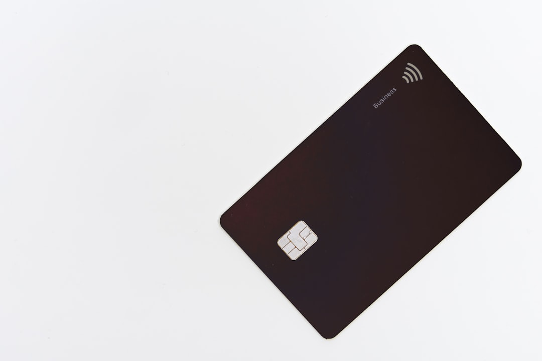 A black business credit card with a chip on a white background