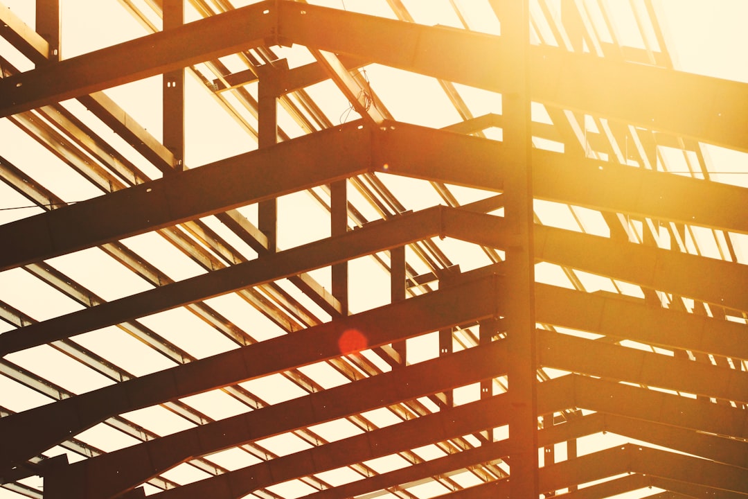 Steel beams forming the roof structure of a building against a bright sky