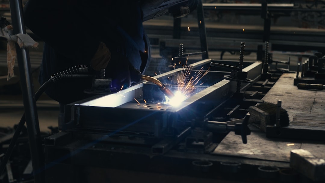 Welder working on a piece of metal in a factory