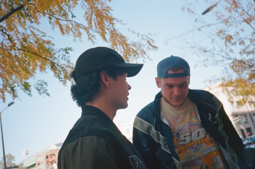 Two men standing next to each other on a street